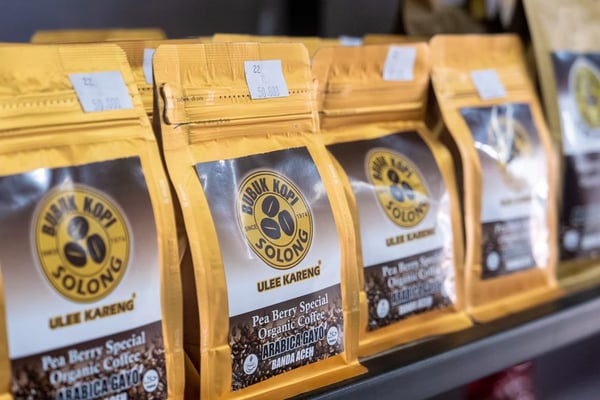 A shelf full of packaged coffee in yellow bags