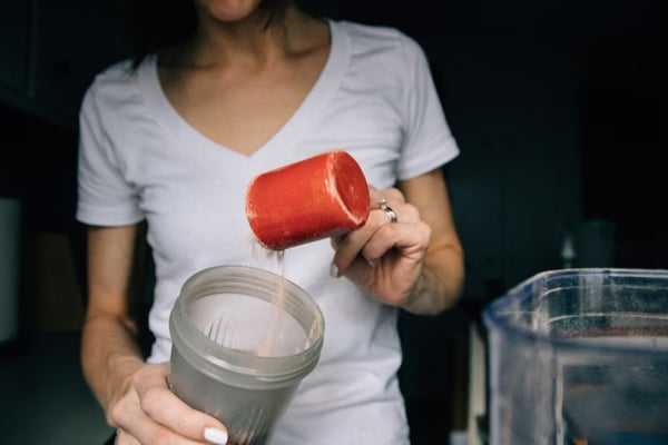 A woman mixing protein powder into her morning drink