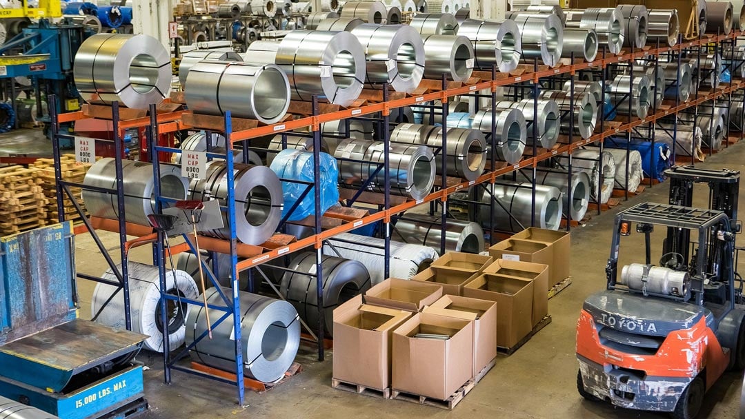 A warehouse full of shelves containing steel cylinders. 