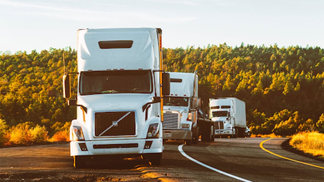 Three-trucks-parked-on-the-side-of-a-rural-road