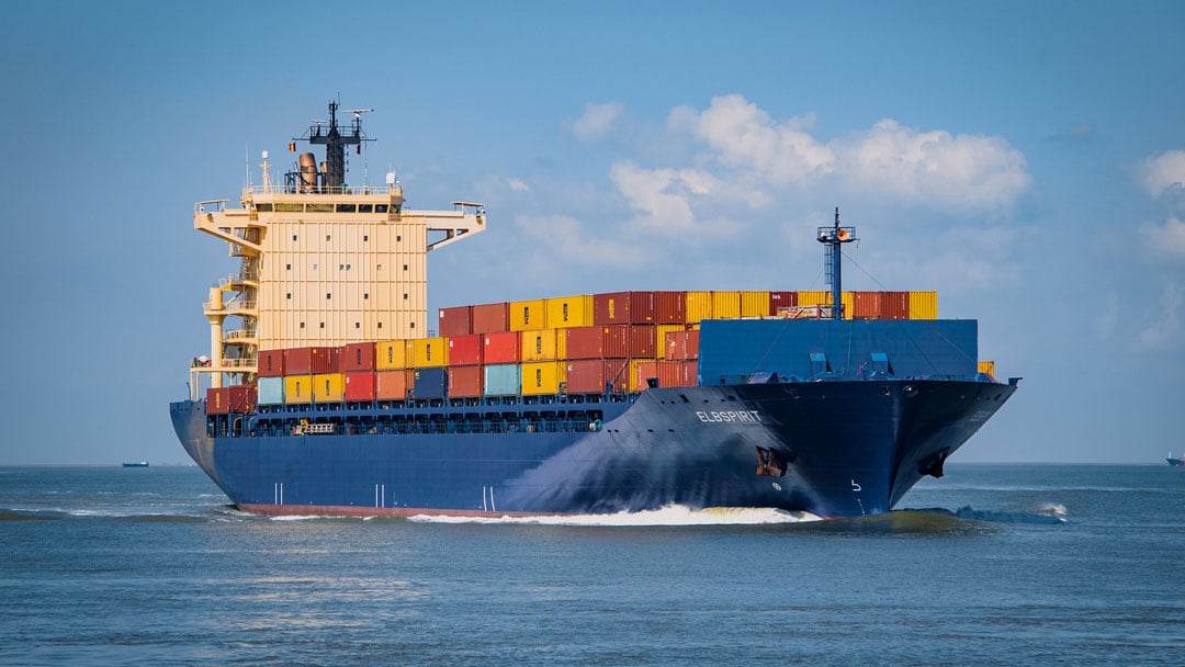 A blue container ship full of cargo.